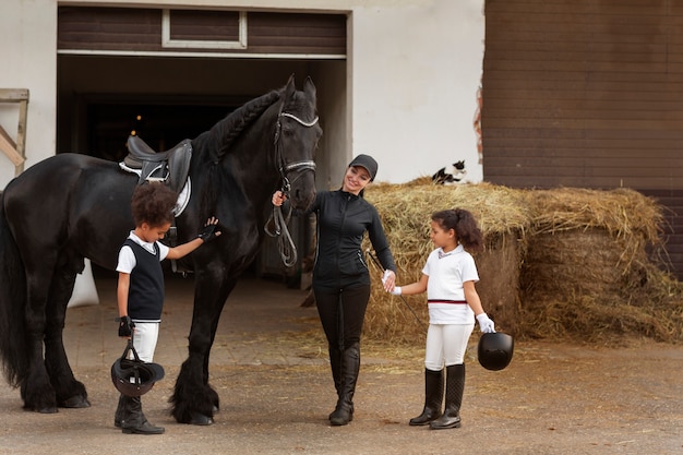 Full shot children learning to ride horses