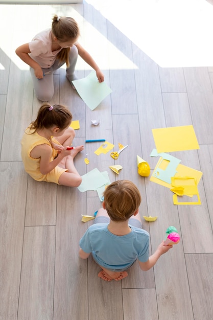 Full shot children playing with paper