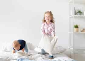 Free photo full shot children playing with pillows