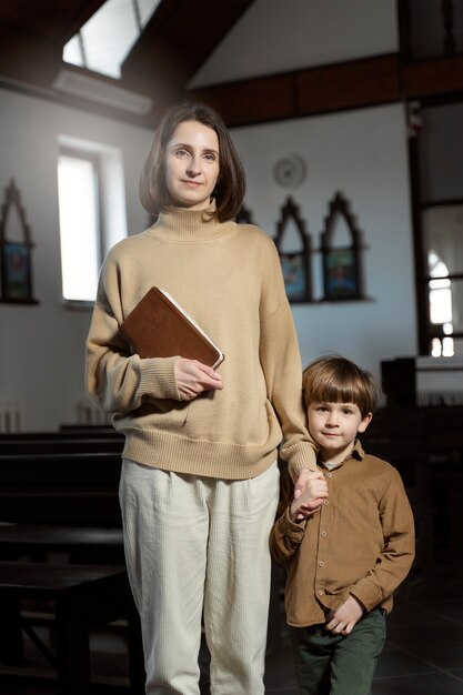 Full shot christian mother and son at church