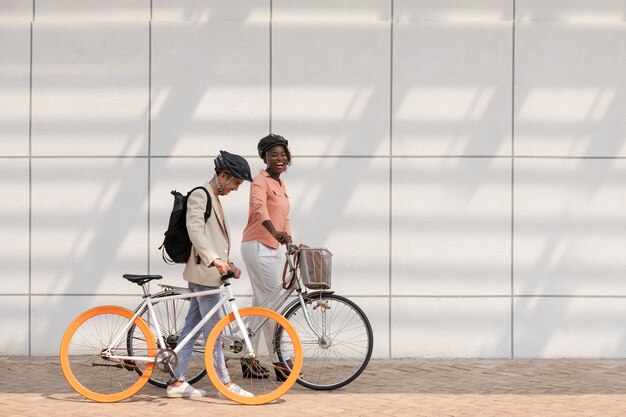 Full shot colleagues going with bicycles