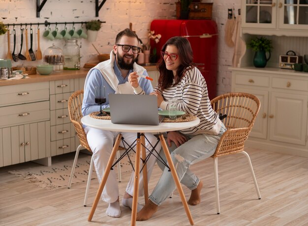 Full shot couple announcing pregnancy with laptop