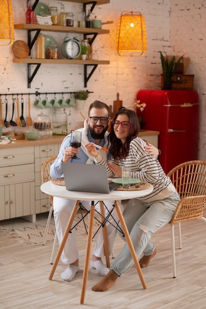 Full shot couple announcing pregnancy with laptop