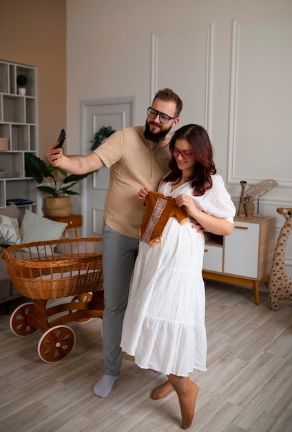 Full shot couple announcing pregnancy with smartphone