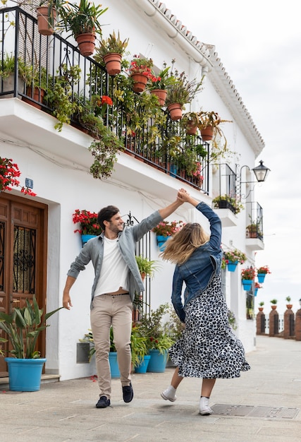 Full shot couple dancing on street