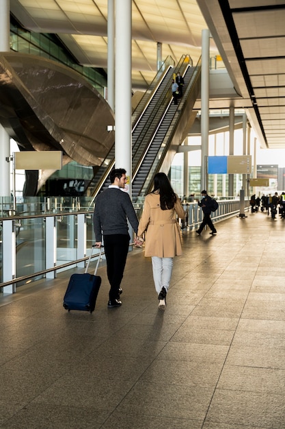 Full shot couple holding hands at airport