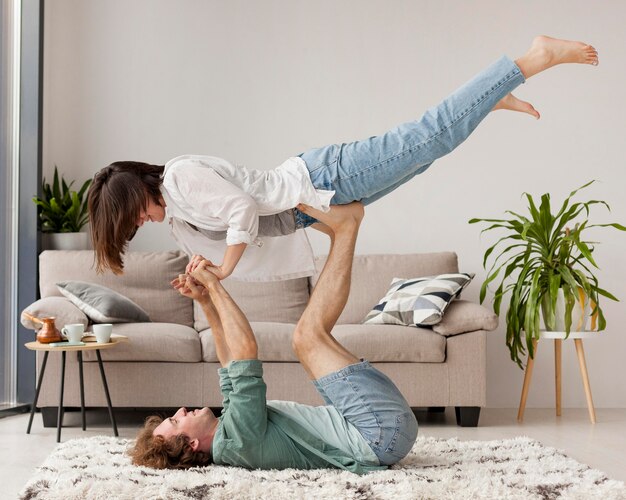 Full shot couple practicing yoga