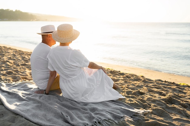 Full shot couple sitting on blanket