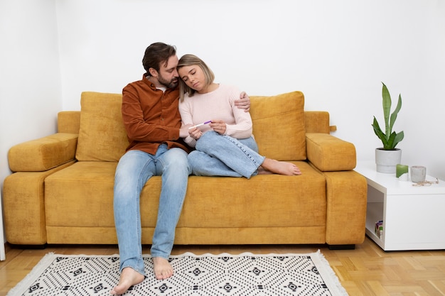 Full shot couple sitting on couch