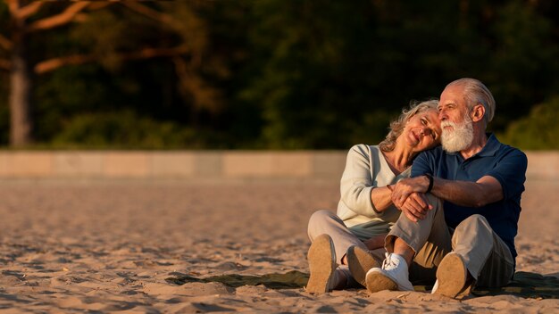 Full shot couple sitting on sand