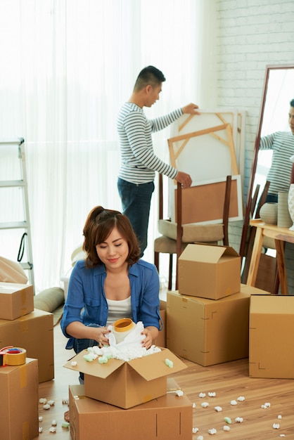 Full shot of couple unpacking belongings in a new apartment