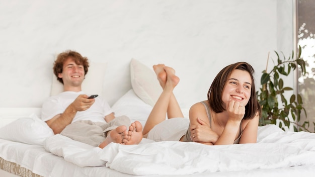 Free Photo full shot couple watching tv together