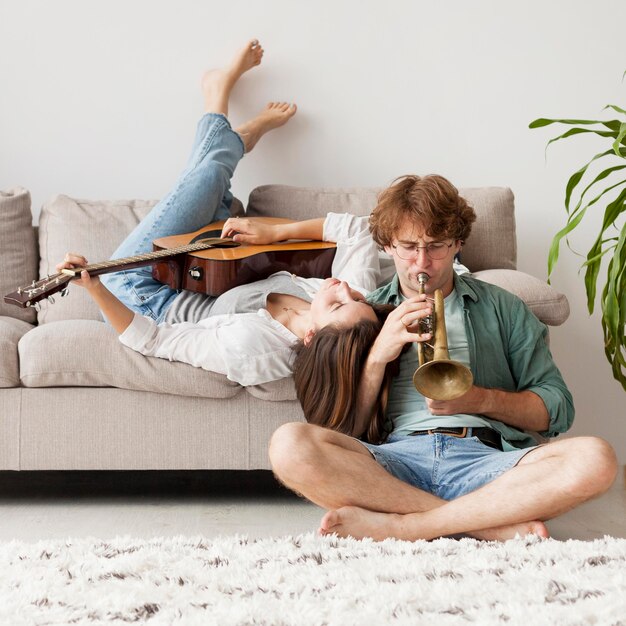 Full shot couple with guitar and trumpet