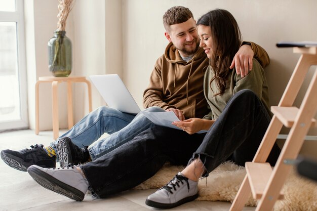 Full shot couple with laptop indoors