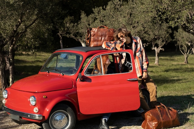 Free photo full shot couple with small car