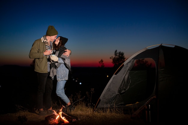 Free photo full shot cute couple kissing in the nature