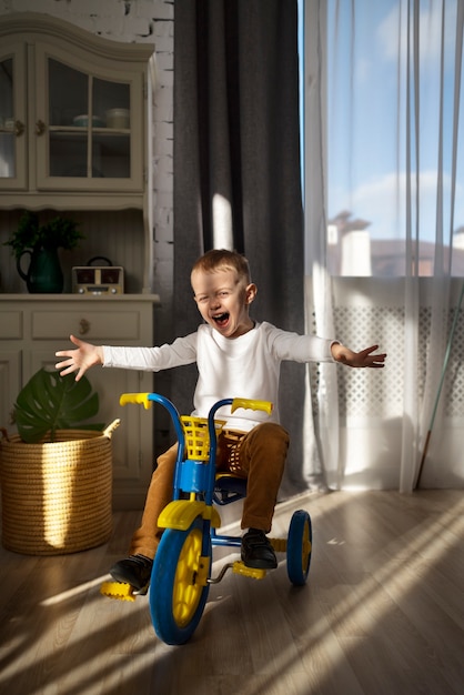 Free photo full shot excited kid on tricycle