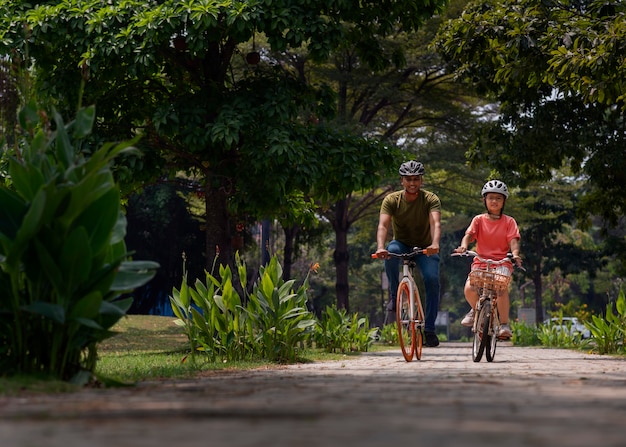 Full shot family cycling outdoors