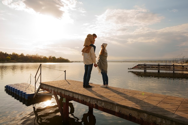 Full shot family hanging out on a jetty