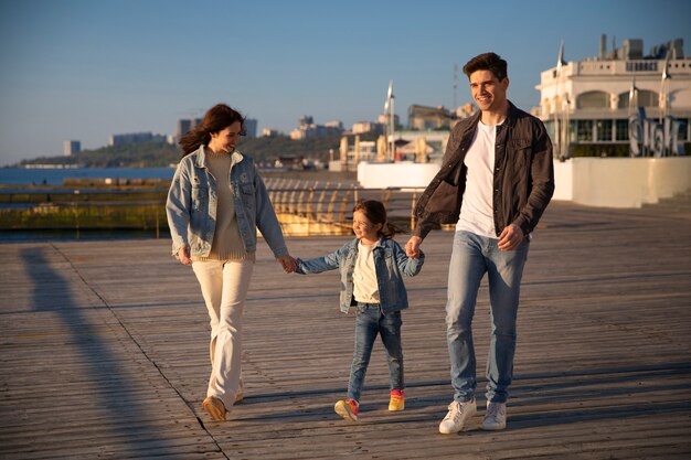 Full shot family hanging out on a jetty