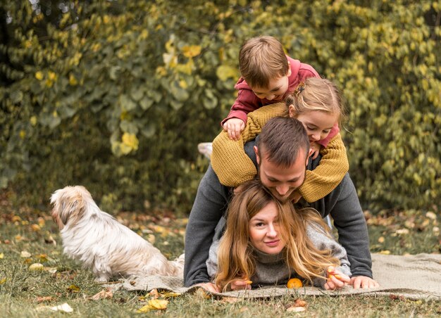 Full shot family having fun with dog