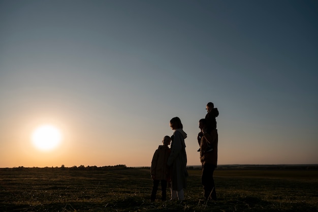 Free Photo full shot family silhouette having fun at sunset