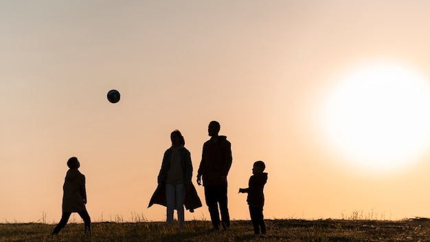 Full shot family silhouette having fun at sunset