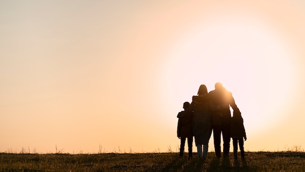 Free Photo full shot family silhouette having fun at sunset