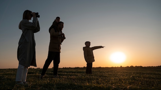 Full shot family silhouette having fun at sunset