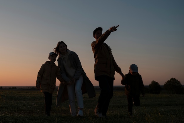 Full shot family silhouette having fun at sunset