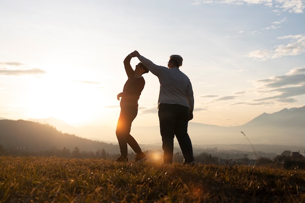 Free photo full shot family silhouette in nature at sunset