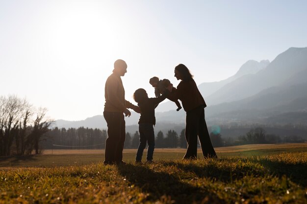 Full shot family silhouette in nature at sunset