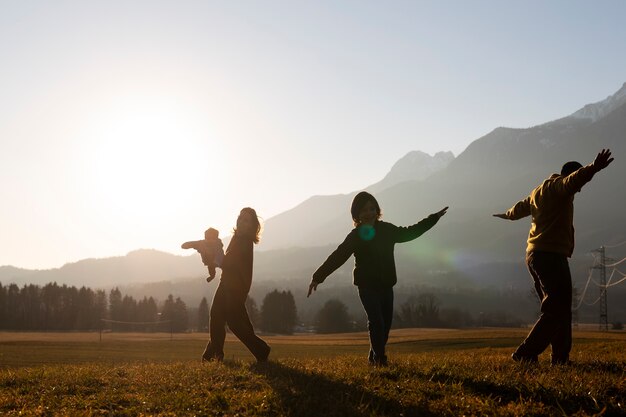 Full shot family silhouette in nature at sunset