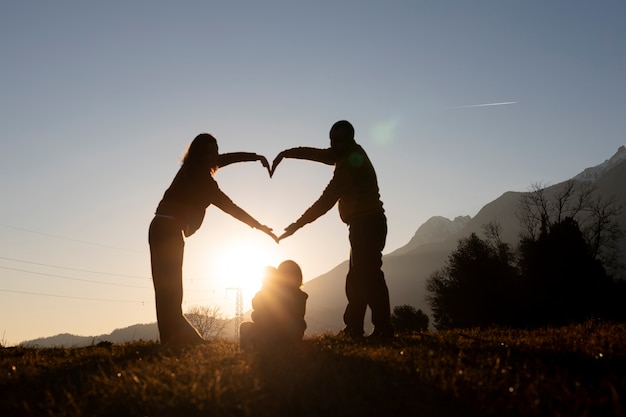 Full shot family silhouette in nature at sunset