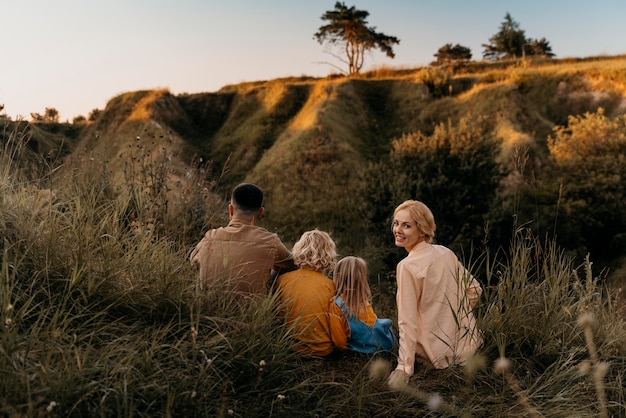 Full shot family sitting on grass together