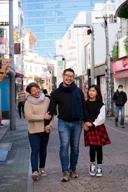 Full shot family walking in city