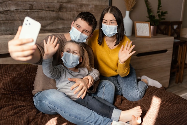 Full shot family wearing masks