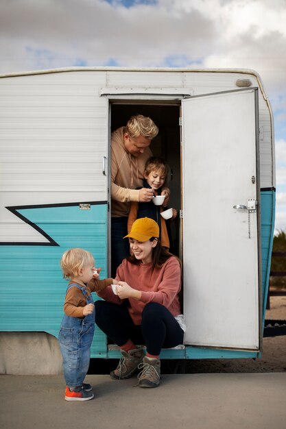 Full shot family with camper van