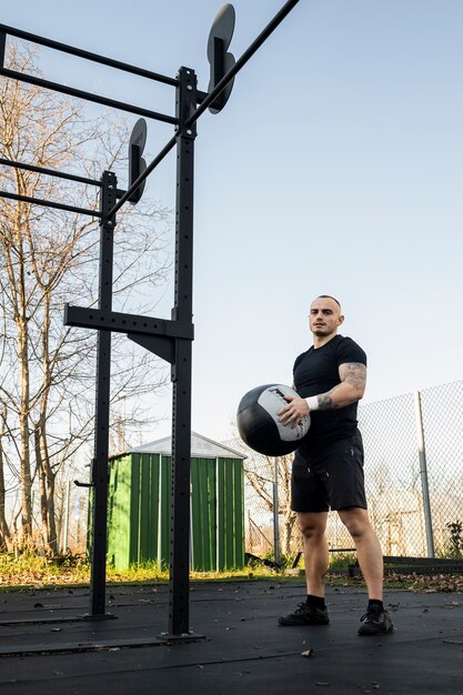 Full shot fit man holding ball