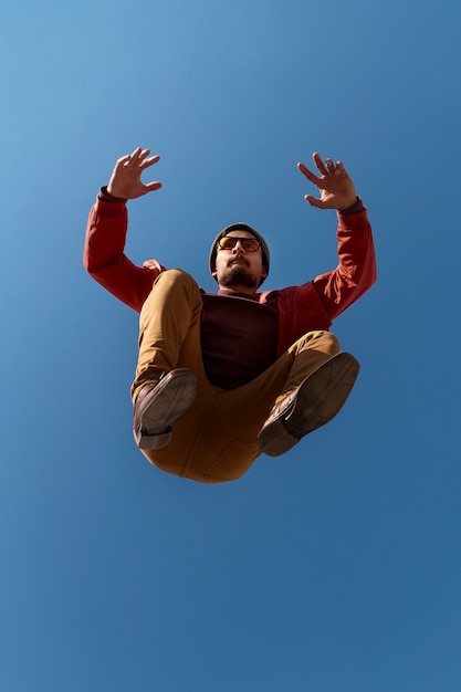 Free photo full shot fit man jumping outdoors