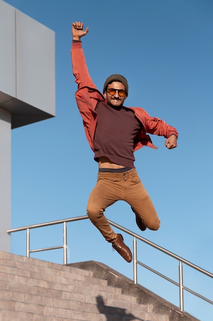 Free photo full shot fit man jumping outdoors