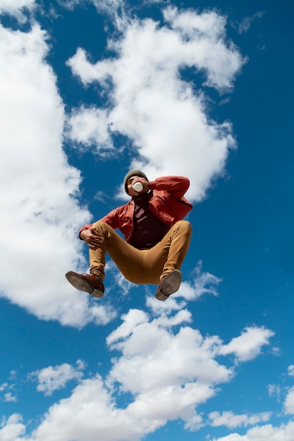 Free photo full shot fit man jumping outdoors