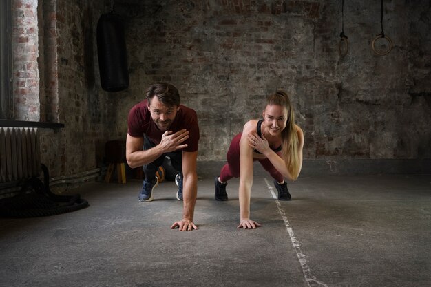 Full shot fit people doing burpees together