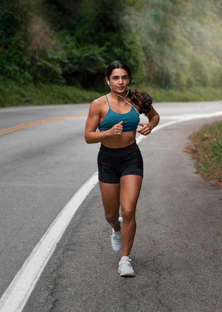 Full shot fit woman running outdoors