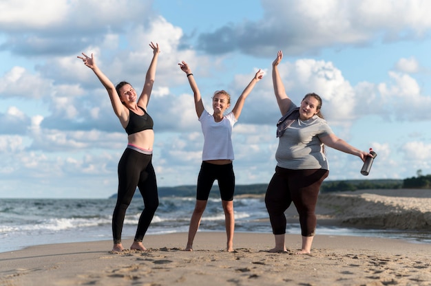 Full shot fitness friends at beach