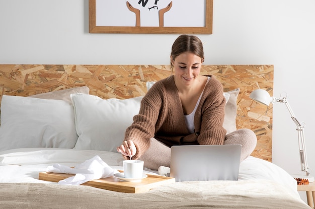 Full shot freelancer working in bedroom