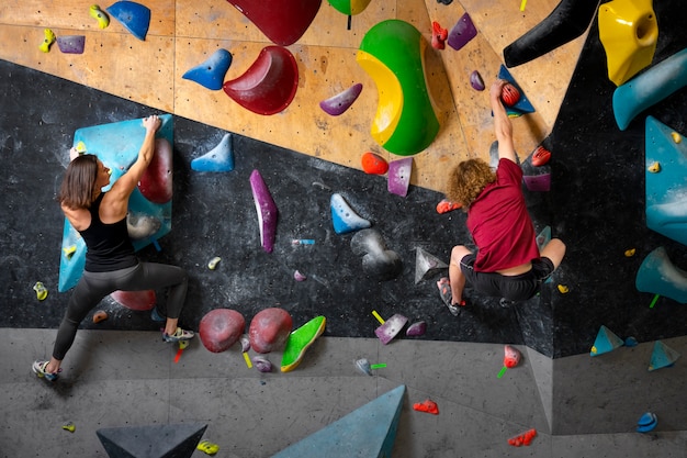 Free photo full shot friends climbing wall together