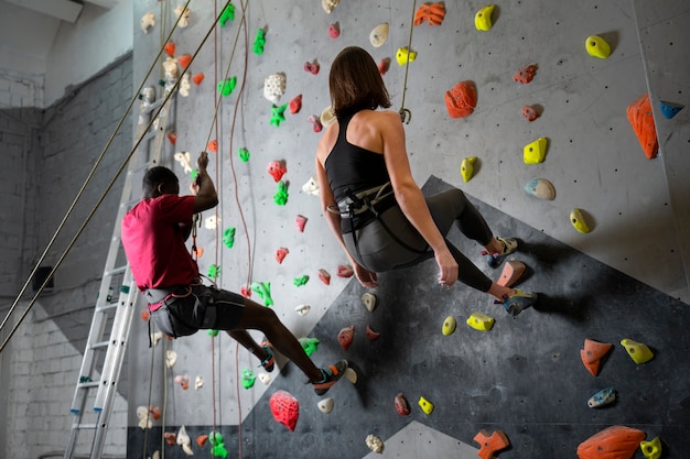 Full shot friends climbing wall together