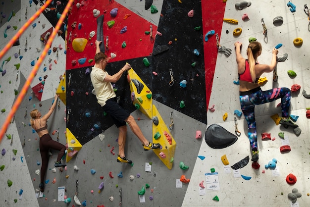 Free Photo full shot friends climbing wall