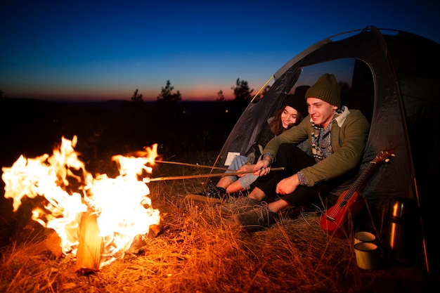 Free Photo full shot friends cooking marshmallows